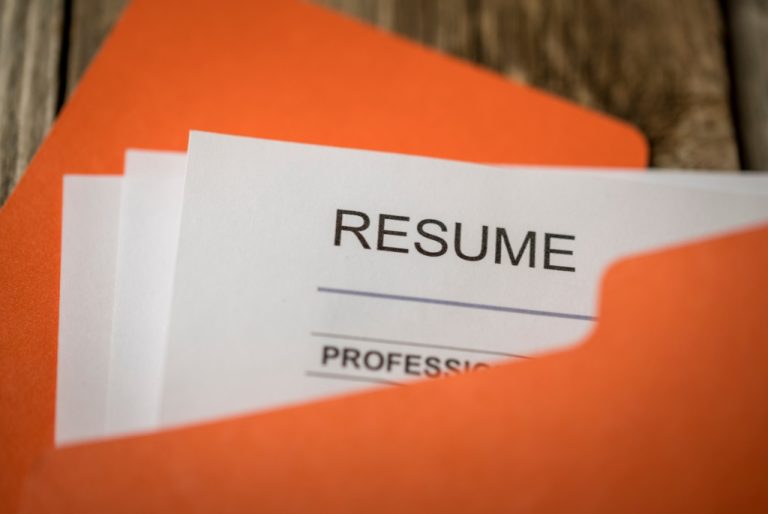 Corner of resume peeking from orange file folder